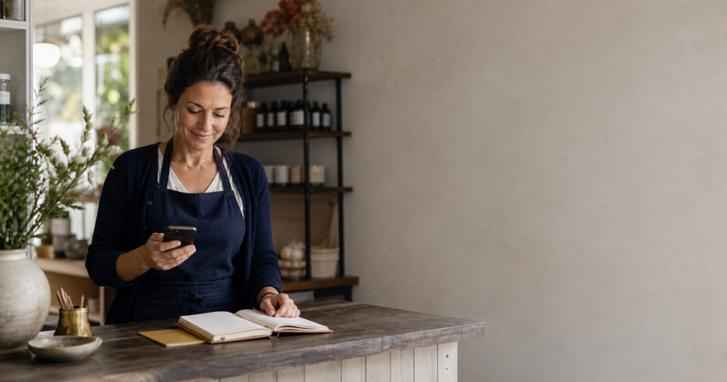 Small business owner checking messages at her shop counter